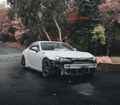 White car with a damaged front bumper