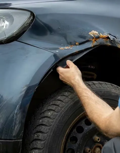 Technician inspecting a damaged front fender