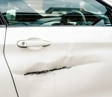 Dented white door panel